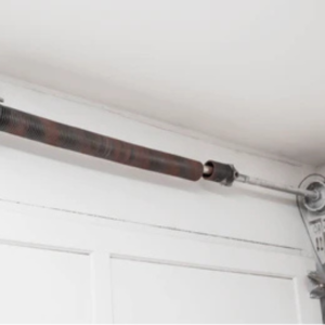 Technician performing garage door torsion spring replacement Summerlin home